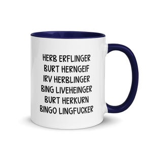 May include: A white ceramic mug with a navy blue interior and handle. The mug features black text listing several names. The mug is designed for beverages and is suitable for home or office use.