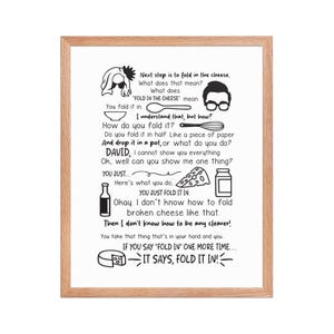 May include: A framed print with a light wood grain border. The print features black and white illustrations and text about folding cheese. The text includes the phrase "FOLD IN THE CHEESE" and other humorous instructions.