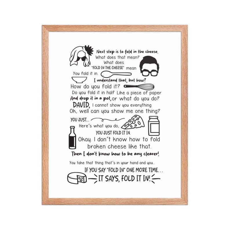 May include: A framed print with a light wood grain border. The print features black and white illustrations and text about folding cheese. The text includes the phrase "FOLD IN THE CHEESE" and other humorous instructions.