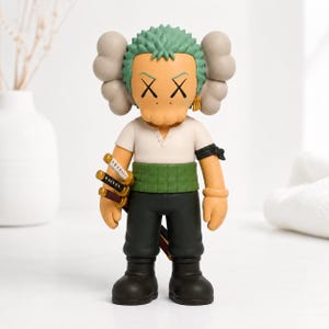 May include: A collectible vinyl figure featuring a character with green hair, X-shaped eyes, and tan skin. The figure wears a white shirt, a green sash, and black pants, and holds three miniature swords at its side with gray cloud-like ears.