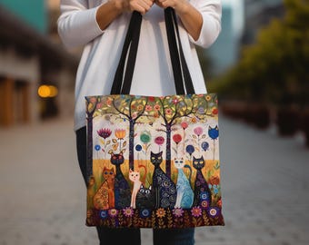 Könnte beinhalten: Eine farbenfrohe Tragetasche mit einem fantasievollen Design, das eine Gruppe von Katzen in einer Waldlandschaft zeigt. Die Katzen sind in verschiedenen Posen und Farben dargestellt, umgeben von Blumen und Bäumen. Die Tasche hat schwarze Henkel und einen weißen Hintergrund.