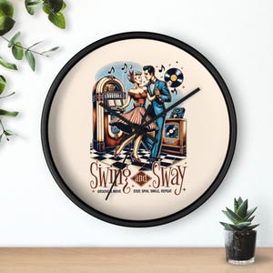 May include: Round wall clock with a black frame featuring a retro illustration of a dancing couple. The clock face has a vintage jukebox, vinyl records, and the words "Swing and Sway". The couple is dressed in 1950s attire.
