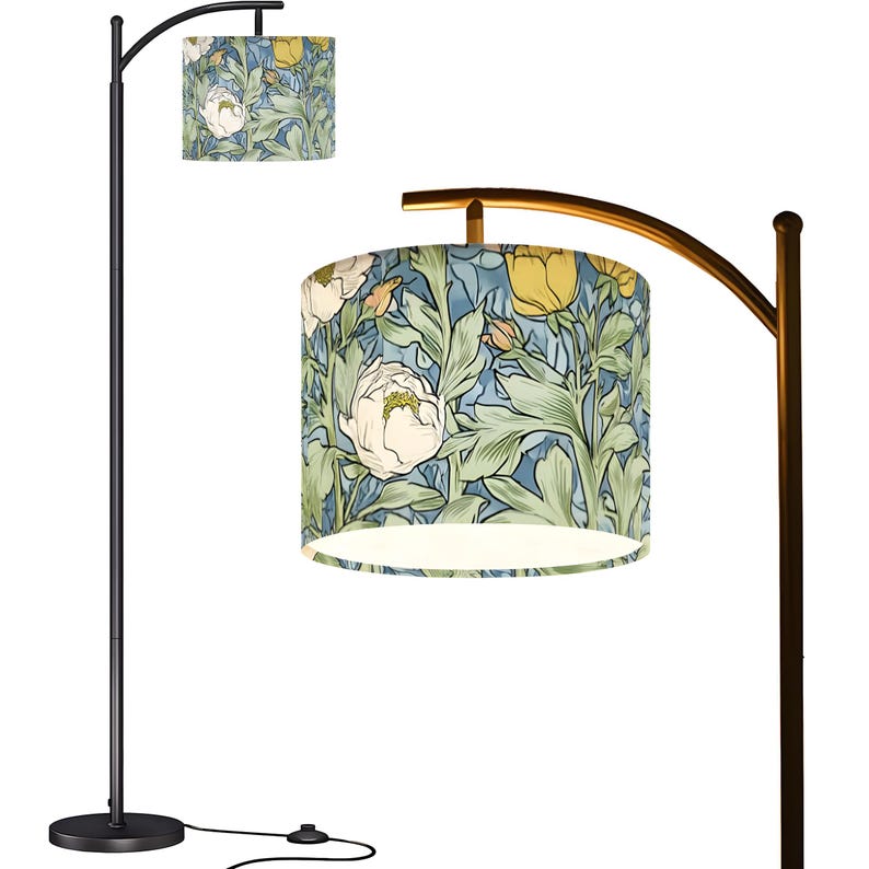 May include: A black arc floor lamp with a floral patterned lampshade. The lampshade features a design of white peonies, yellow flowers, and green leaves on a blue background. The lamp has a round base and a curved arm.
