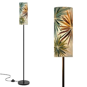 May include: A floor lamp with a tall, thin black metal pole and a cylindrical lampshade. The shade features a cream background with a repeating pattern of starburst-like botanical shapes in shades of teal, olive green, and burnt orange.