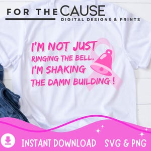 May include: White t-shirt with pink text that reads "I'M NOT JUST RINGING THE BELL. I'M SHAKING THE DAMN BUILDING!" and a pink bell graphic. The shirt also has the text "FOR THE CAUSE DIGITAL DESIGNS & PRINTS".