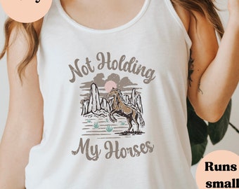 May include: White tank top with a brown horse graphic and the text "Not Holding My Horses".