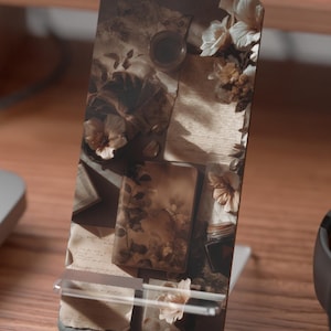 Pages, paper, soft shadows —
the kind of atmosphere that makes you slow down without trying.

This bookish phone stand brings a warm, vintage-inspired feel to your space, blending softly layered textures with a calm, grounded aesthetic.

Perfect for reading, writing, working — or simply creating a space that feels like your own.