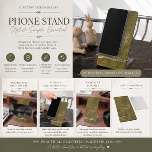 May include: A phone stand with a green and gold floral design, holding a black smartphone. The stand is made of acrylic and features the text "PHONE STAND Stylish Simple Essential". It is designed for everyday use.