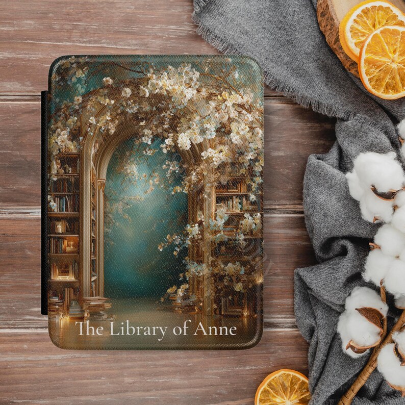 Personalized Kindle case with antique library arch design displayed on a wooden desk with books and warm lighting.