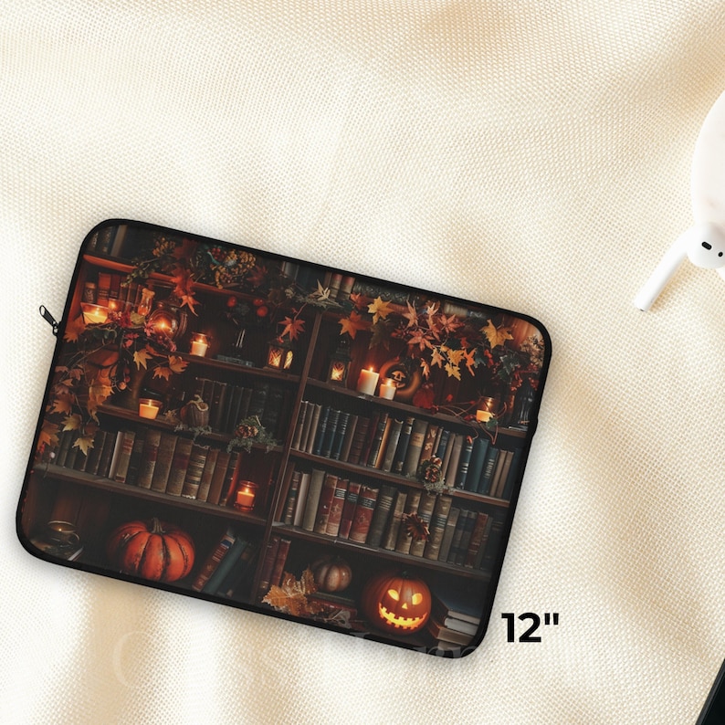 Vintage library laptop sleeve with books, glowing candles, pumpkins, and autumn leaves, protective fleece case in 12, 13, and 15 inch sizes