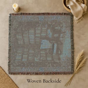 Woven blanket with a warm storybook library scene, draped over a reading chair.