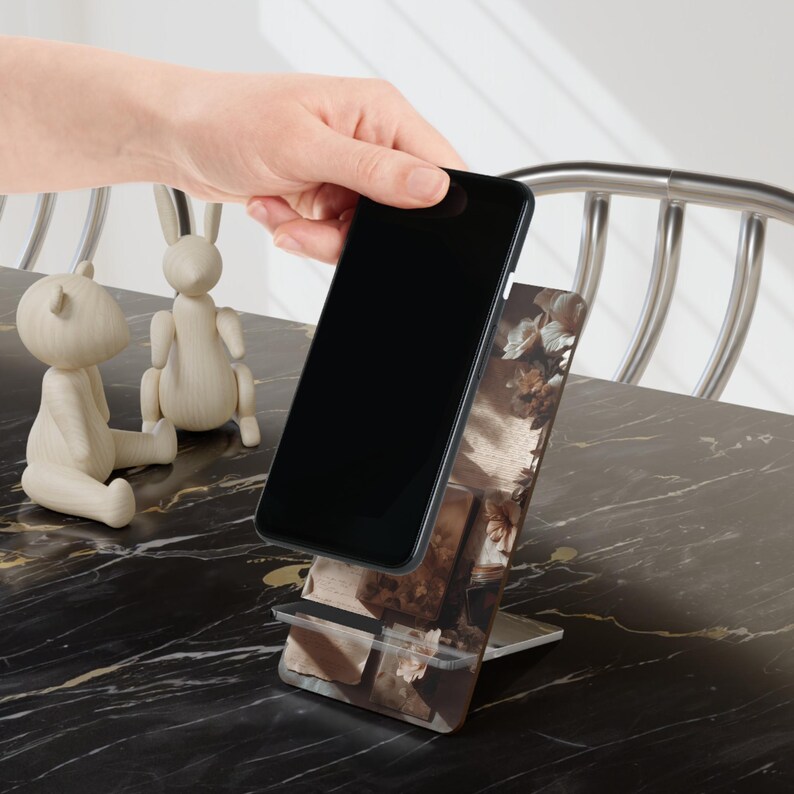 Pages, paper, soft shadows —
the kind of atmosphere that makes you slow down without trying.

This bookish phone stand brings a warm, vintage-inspired feel to your space, blending softly layered textures with a calm, grounded aesthetic.

Perfect for reading, writing, working — or simply creating a space that feels like your own.