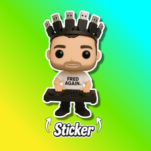 May include: A Funko Pop vinyl figure of a man wearing a crown of USB cables and holding a DJ mixer. The figure is wearing a white t-shirt with the text "FRED AGAIN..". A sticker with the word "Sticker" is at the bottom.
