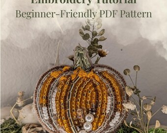 Może przedstawiać: Wzór haftu dyni z koralikami z tekstem "Embroidery Tutorial Beginner-Friendly PDF Pattern". Dynia jest pomarańczowa, brązowa i biała, z zieloną łodygą i białymi perłowymi akcentami. Projekt jest na neutralnym tle.