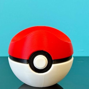 K&ouml;nnte beinhalten: Ein rot-wei&szlig;er Pok&eacute;ball, ein kugelf&ouml;rmiges Ger&auml;t aus dem Pok&eacute;mon-Franchise. Die obere H&auml;lfte ist rot, die untere H&auml;lfte ist wei&szlig;, mit einem schwarzen Band und einem wei&szlig;en Knopf in der Mitte. Der Hintergrund ist t&uuml;rkis.