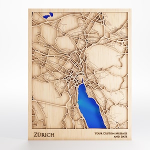 Könnte beinhalten: Eine Holzkarte von Zürich, Schweiz, mit einem blauen See-Ausschnitt. Die Karte ist gerahmt und hat den Schriftzug "Zürich" und "Ihre individuelle Nachricht und Datum" darunter.
