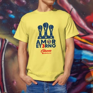 Op de afbeelding: Geel T-shirt met een blauwe afbeelding van drie voetbalbekers, de tekst "AMOR ETERNO 3", een voetbal en de tekst "Culiacan #culiacan.mx".