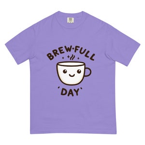 May include: A lavender t-shirt with a cartoon coffee cup and the text "Brew-Full 'Day'".