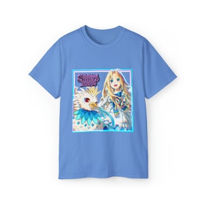 May include: A light blue t-shirt featuring a graphic print of a girl with long blonde hair and a white bird. The graphic is surrounded by a blue and pink border. The text "The Rising of the Shield Hero" is printed in purple on the graphic.