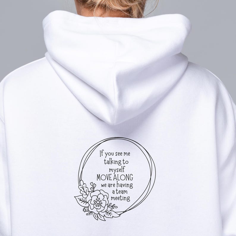 May include: White hoodie with a black graphic print that says "If you see me talking to myself MOVE ALONG we are having a team meeting". The graphic is in a circle with a floral design.