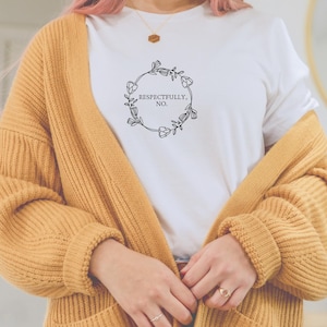 May include: White t-shirt with a floral wreath design and the text "Respectfully, No."