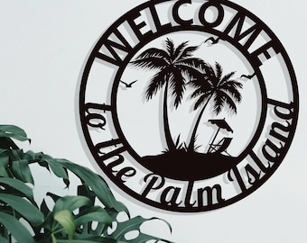 Puede incluir: Señal de metal negro con el texto "Bienvenido a la Isla de las Palmas" en un círculo con palmeras y una silla de playa en su interior.