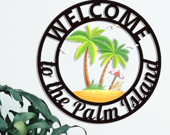 Könnte beinhalten: Schwarzes Metallschild mit dem Text "Willkommen auf der Palmeninsel" in einem Kreis mit Palmen und einer Strandszene im Inneren.