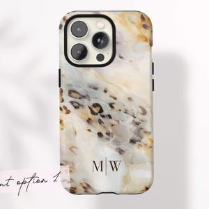 Op de afbeelding: Een smartphonehoesje met een marmerpatroon in crème, bruin en bruin, geaccentueerd met zwart. De hoes heeft een zwarte rand en een camera-uitsparing. De initialen "MW" worden verticaal weergegeven. De woorden "font option 1" zijn cursief geschreven.