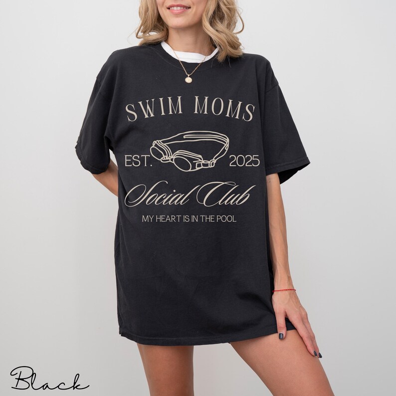 Puede incluir: Una camiseta negra con texto blanco que dice SWIM MOMS EST. 2025 Social Club MY HEART IS IN THE POOL, con un gr&aacute;fico de l&iacute;neas de unas gafas de nataci&oacute;n centrado entre los elementos de texto.