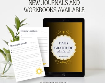 May include: A digital tablet displays a "Daily Gratitude Mini Journal" design. Two printed gratitude journals are in front of the tablet. The text "New Journals and Workbooks Available" is at the top. A plant in a glass vase is on the left.