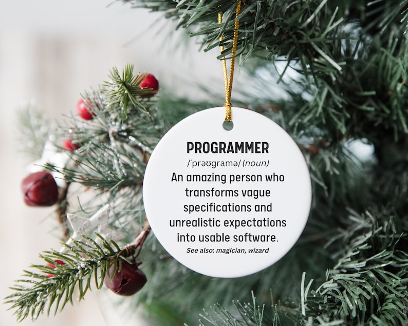May include: White ceramic Christmas ornament with the word "PROGRAMMER" and a definition: "An amazing person who transforms vague specifications and unrealistic expectations into usable software. See also: magician, wizard."
