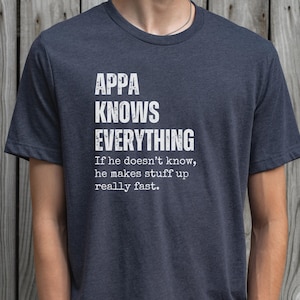 May include: Dark blue t-shirt with the text "APPA KNOWS EVERYTHING" in white block letters. Below the text is the phrase "If he doesn't know, he makes stuff up really fast."