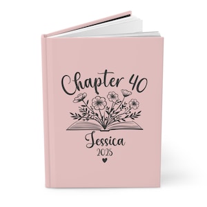 May include: A pink hardcover journal with the text "Chapter 40" and a floral design. The name "Jessica" and the year "2025" are printed below the floral design.