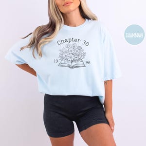 May include: Light blue t-shirt with the text "Chapter 30" above a floral design and the numbers "1996". The shirt is a soft, comfortable material.
