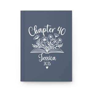 May include: A blue journal cover with white text that reads "Chapter 40 Jessica 2025" and a white illustration of a book with flowers coming out of it.