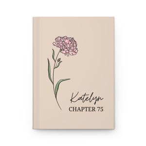 Peut inclure: Un journal beige avec une illustration de fleur rose et des feuilles vertes. Le texte "Katelyn CHAPTER 75" est écrit en script noir. Le journal a un design épuré et minimaliste.