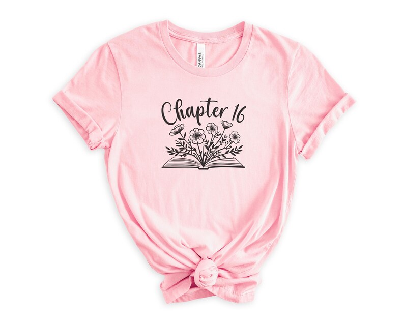 May include: Pink t-shirt with a black graphic of an open book with flowers and the text "Chapter 16".