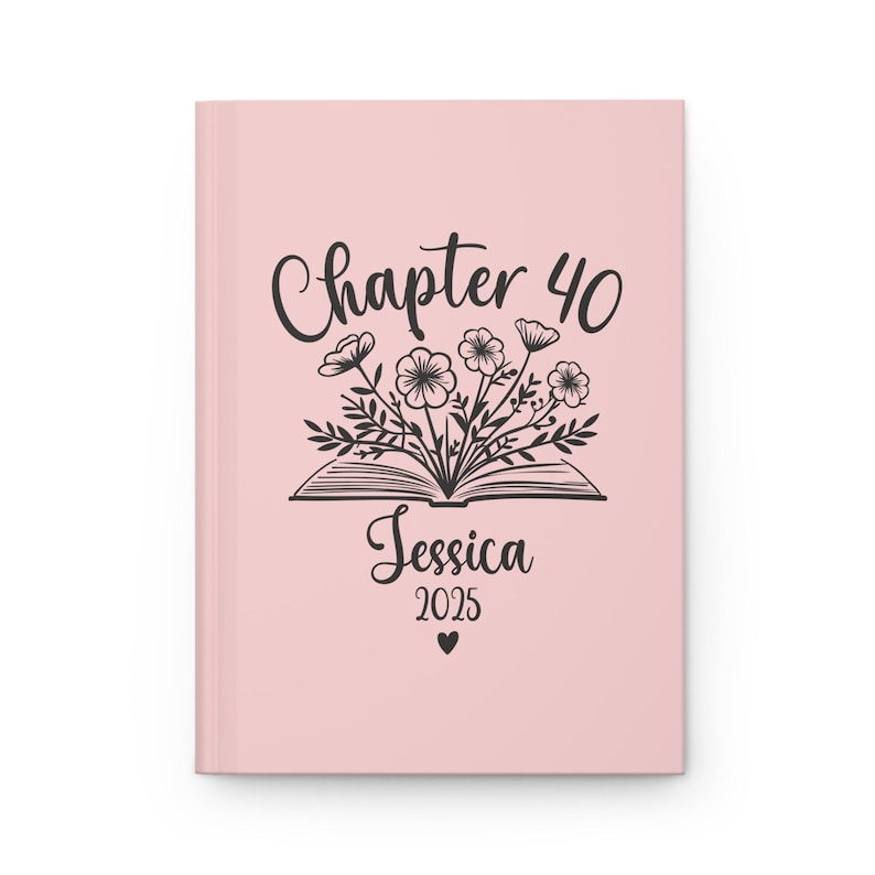 May include: Pink journal cover with a black and white illustration of a book with flowers coming out of it. The text "Chapter 40" is above the book and the text "Jessica 2025" is below the book.