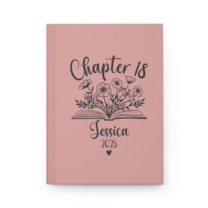 Peut inclure: Une couverture de journal rose poudré avec un motif floral noir et le texte "Chapter 18 Jessica 2025" avec un petit cœur.