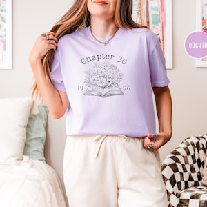 May include: A light purple t-shirt with the text "Chapter 30" above a floral design and the numbers "1996". The shirt is a soft, comfortable material.