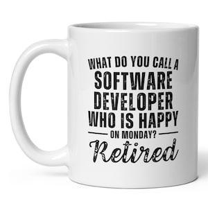 May include: White ceramic coffee mug with a black graphic that reads "What do you call a software developer who is happy on Monday? Retired."