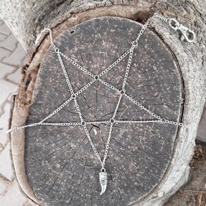 May include: A silver chain body harness with a pentagram design and a silver horn pendant.