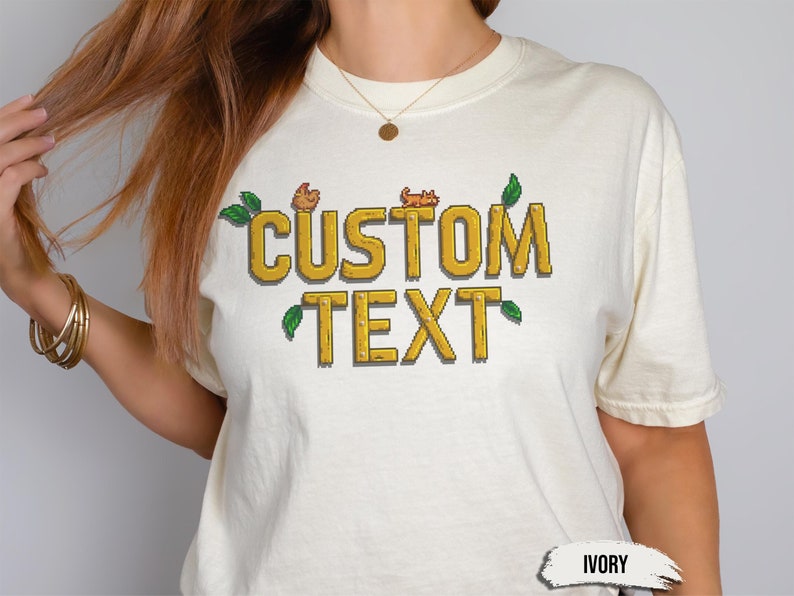 Comfort Colors gamer t-shirt in pixel art style, inspired by Stardew Valley. Customizable with your own text. Soft, retro style perfect for gamers and casual wear