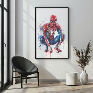 Pu&ograve; includere: Un'illustrazione incorniciata di Spider-Man con un costume rosso e blu, accovacciato con le braccia distese. Lo sfondo &egrave; bianco con schizzi di acquerello blu e rosso.