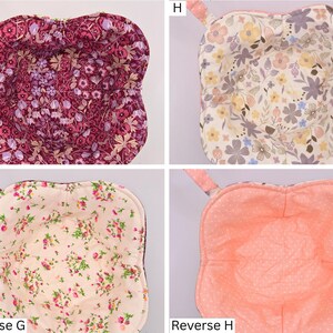 May include: Four quilted bowl cozies with floral patterns. The top left cozy has a burgundy floral design, the top right has a cream floral pattern, the bottom left has a pink floral pattern, and the bottom right is peach with white polka dots. Each has a fabric loop.