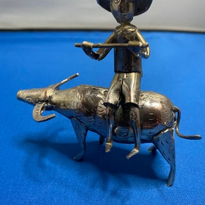 Silver Nepalese figure riding on small water buffalo