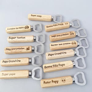 Peut inclure: Plusieurs ouvre-bouteilles en bois avec des têtes en acier inoxydable. Chaque manche en bois est gravé de phrases telles que "Super Papy", "Bonne Fête Papy", et "Futur Papy".