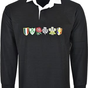 May include: Black long-sleeve rugby shirt with a white collar. The shirt features embroidered emblems of various nations across the chest. The word "Rugby" is printed on the collar.
