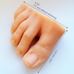 May include: A close-up of a realistic-looking silicone foot model. The foot is 4.33 inches (11 cm) long and 3.93 inches (10 cm) wide. The foot is unpainted and has a natural skin tone.