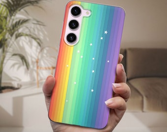 Puede incluir: Una funda transparente para teléfono con un diseño de rayas arcoíris y estrellas blancas. La funda tiene una protuberancia de cámara elevada con tres lentes de cámara negras.
